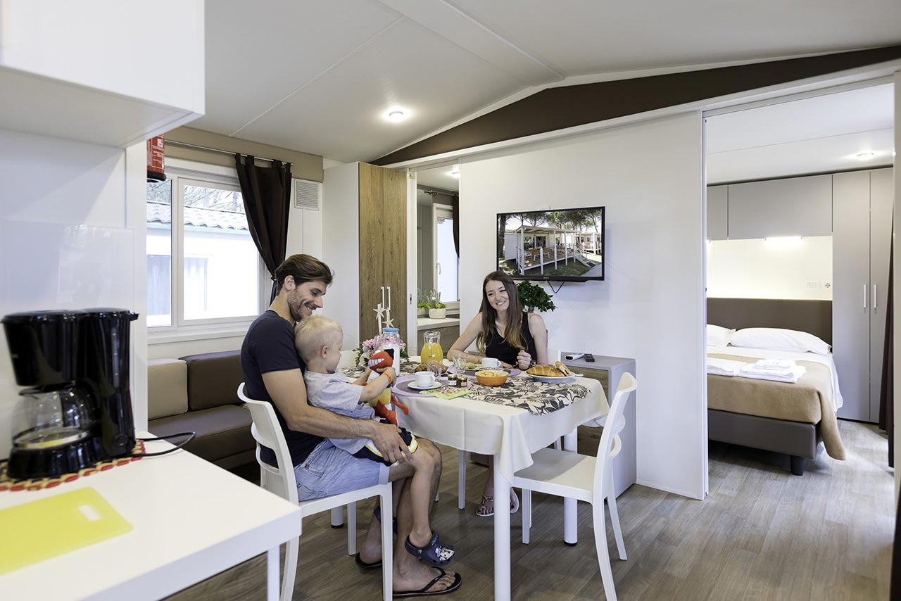 Famiglia fa colazione nel soggiorno di una mobile home