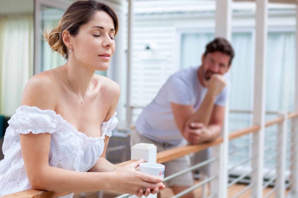 Coppia con caffè affacciata alla veranda di una mobile home.