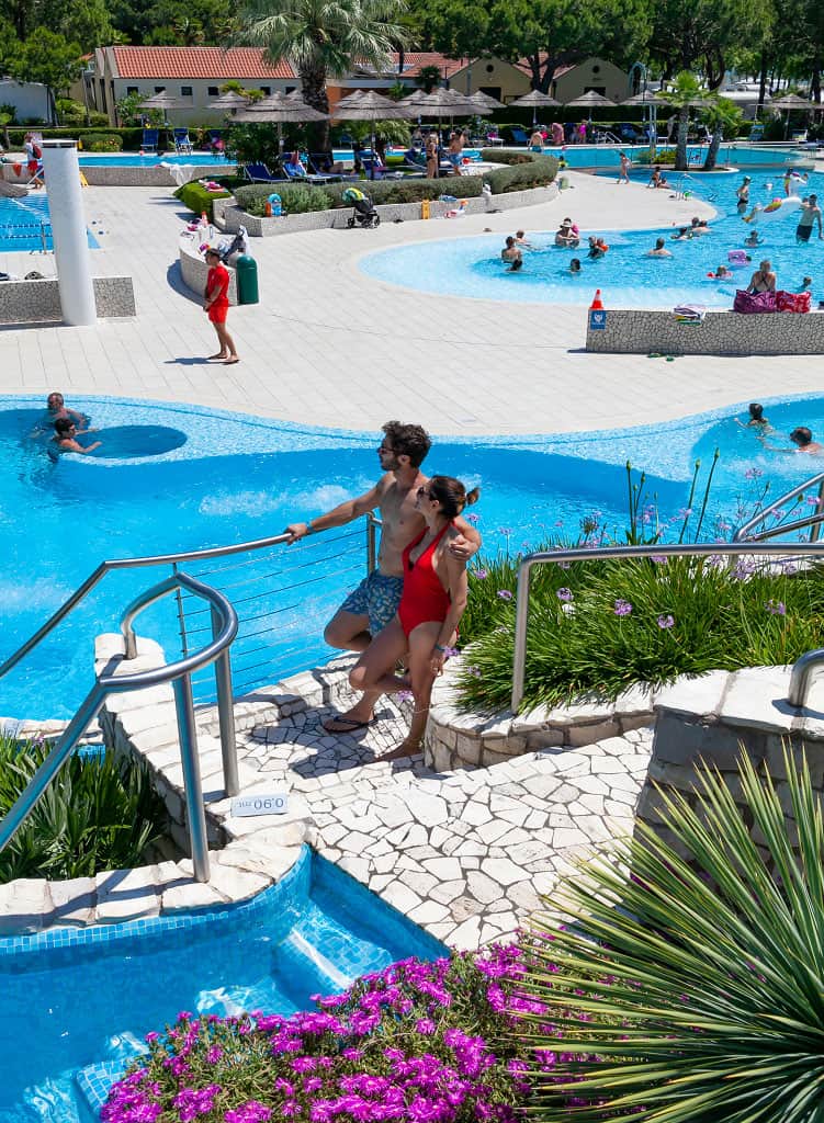 Coppia a bordo piscina nel parco acquatico