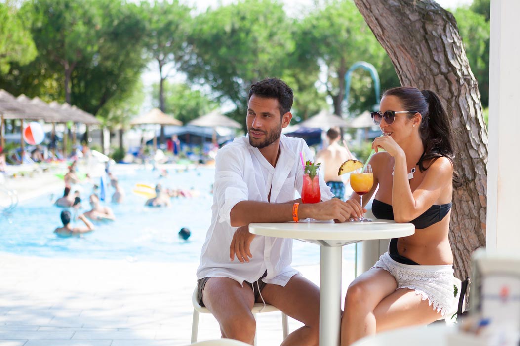 Coppia sorseggia un cocktail nel pool bar a bordo piscina