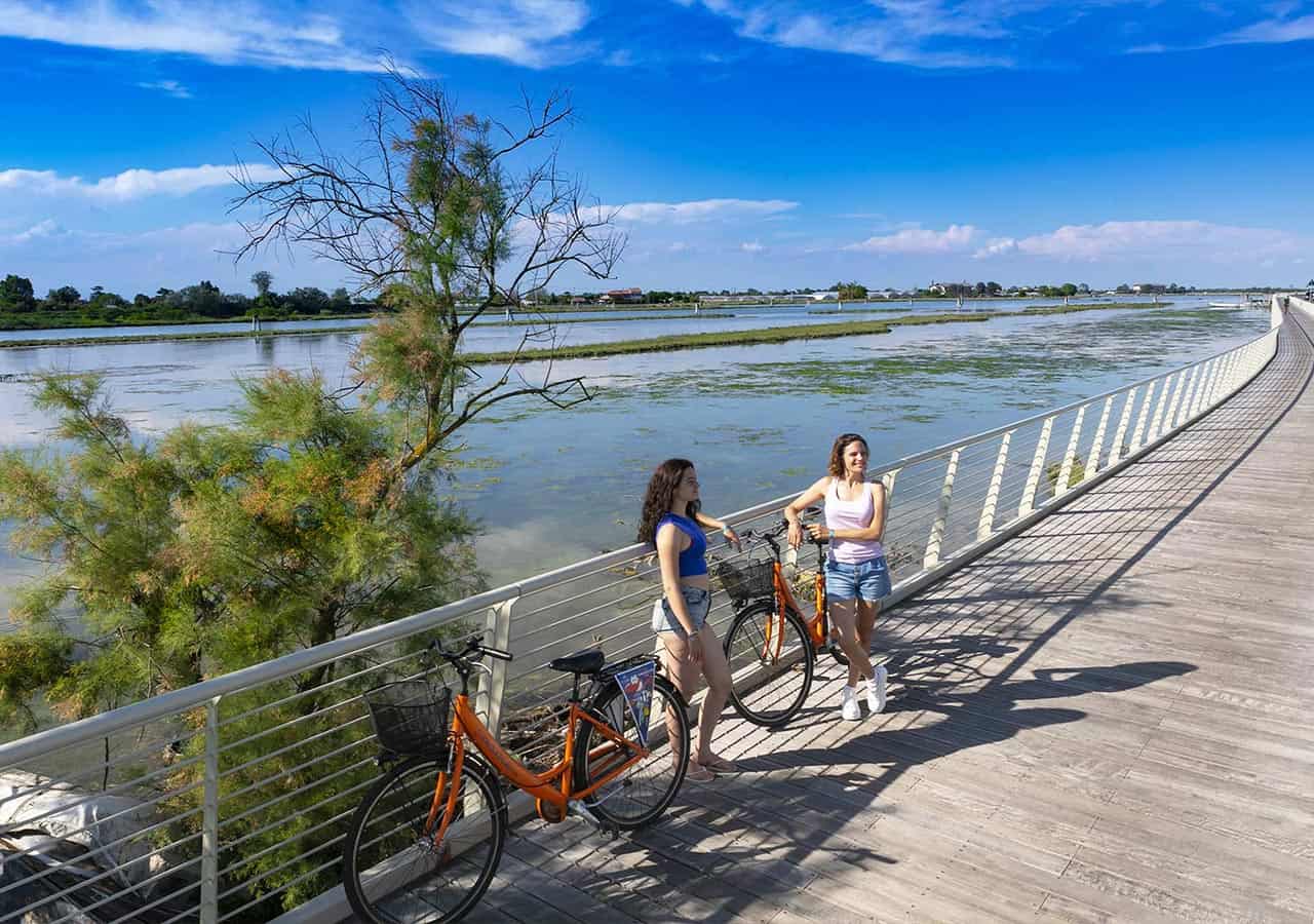 Due ragazze in bici sulla ciclabile della laguna