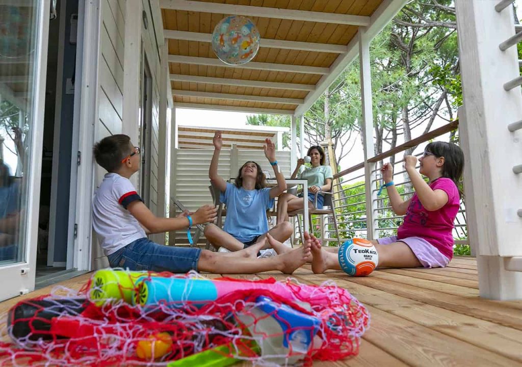 Tre bambini giocano nella veranda di una mobile home